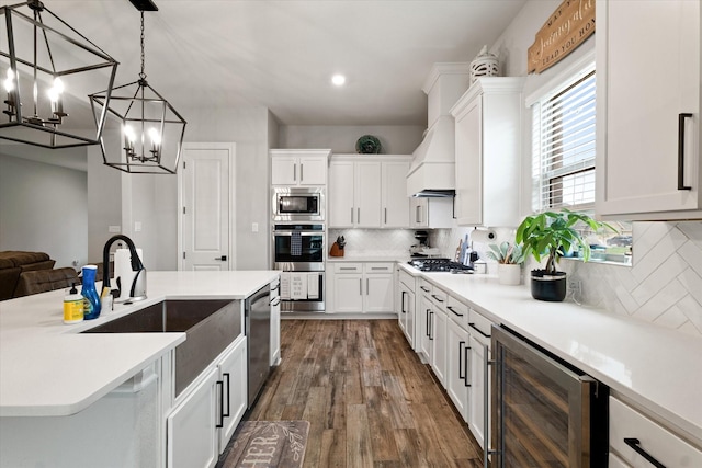 kitchen with pendant lighting, white cabinetry, stainless steel appliances, wine cooler, and decorative backsplash