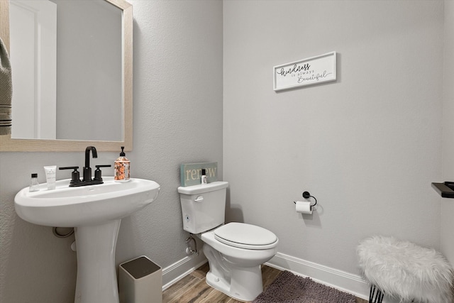 bathroom featuring hardwood / wood-style flooring and toilet