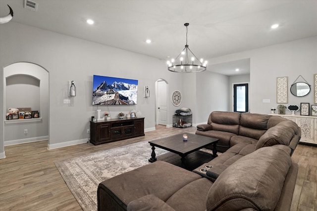 living room with light hardwood / wood-style flooring and a chandelier