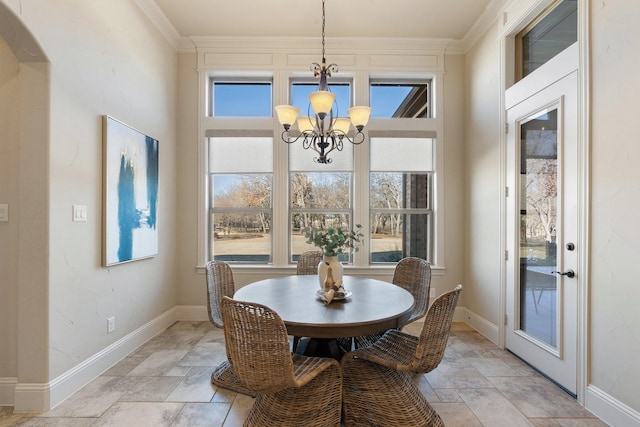 dining area with crown molding, plenty of natural light, and a notable chandelier