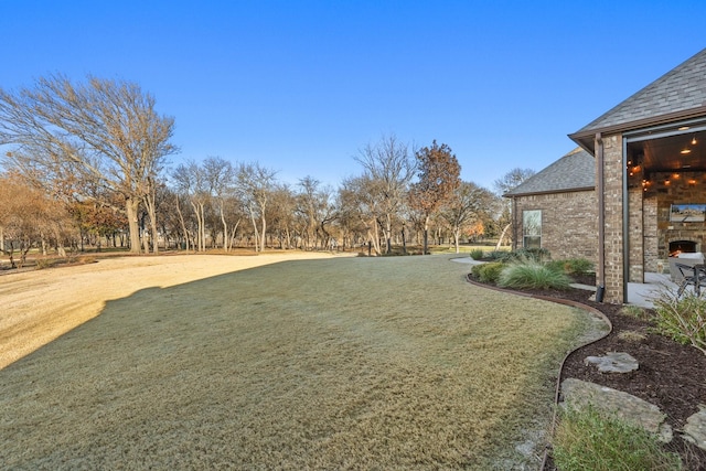 view of yard featuring an outdoor stone fireplace