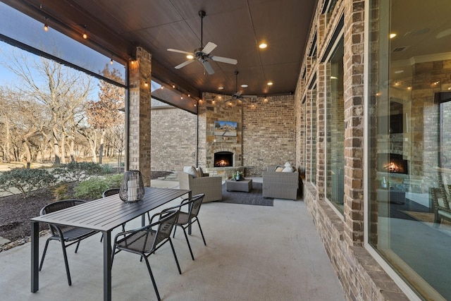 view of patio / terrace featuring ceiling fan and an outdoor living space with a fireplace