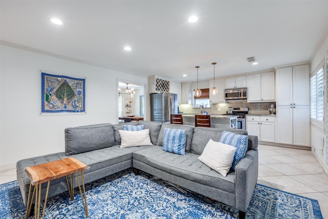 tiled living room featuring ornamental molding, a chandelier, and a healthy amount of sunlight