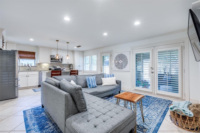 living room featuring sink, a wealth of natural light, and light tile patterned flooring