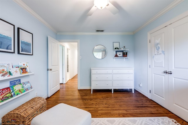 bedroom featuring dark hardwood / wood-style flooring, crown molding, ceiling fan, and a closet