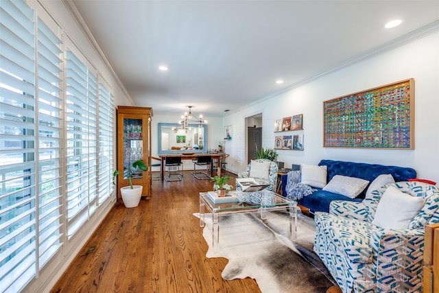 living room featuring crown molding, hardwood / wood-style flooring, and a chandelier