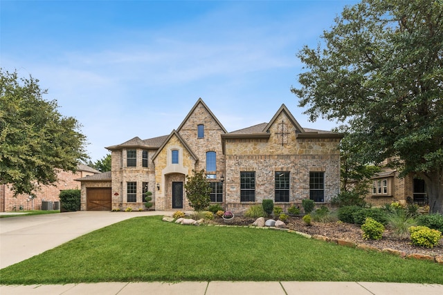 tudor house with a garage, central AC unit, and a front lawn