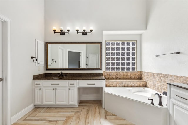 bathroom with vanity, a washtub, and parquet flooring