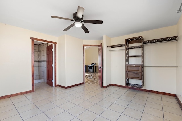 unfurnished bedroom featuring ensuite bathroom, light tile patterned flooring, and ceiling fan