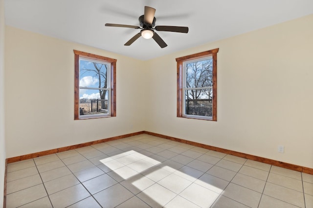 tiled spare room featuring ceiling fan