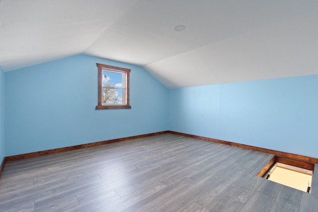 additional living space with lofted ceiling and hardwood / wood-style floors