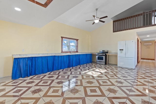 interior space with white fridge with ice dispenser, light tile patterned floors, ceiling fan, kitchen peninsula, and gas range