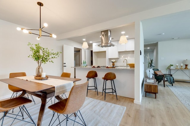 dining room featuring sink and light hardwood / wood-style floors