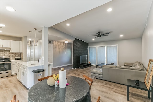 interior space featuring a fireplace, light hardwood / wood-style floors, and ceiling fan