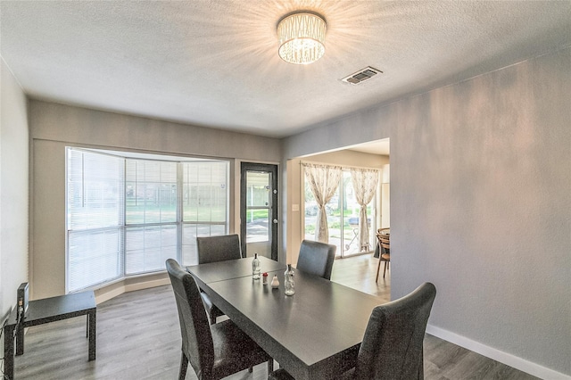 dining space featuring hardwood / wood-style flooring and a textured ceiling