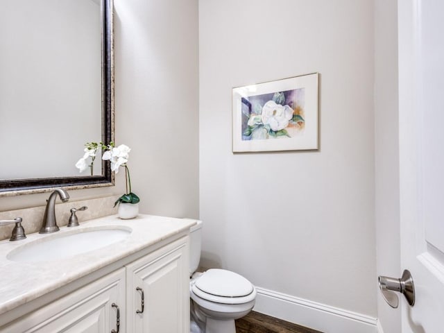 bathroom featuring vanity, hardwood / wood-style flooring, and toilet