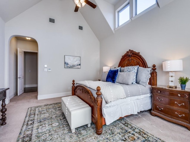 carpeted bedroom with a high ceiling and ceiling fan