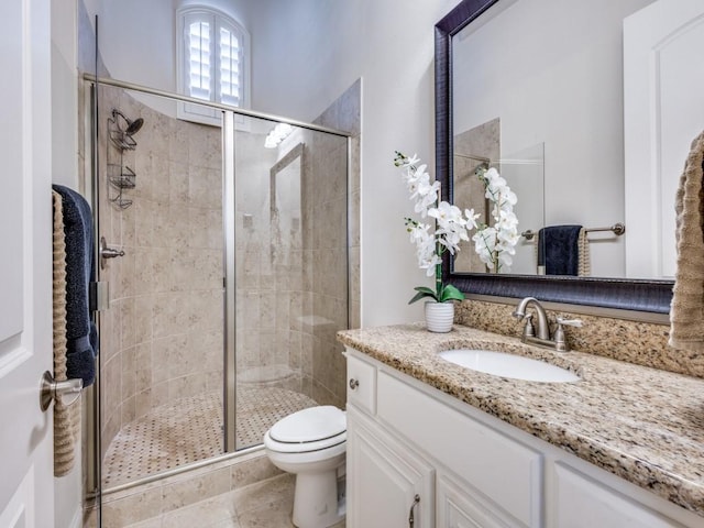 bathroom featuring tile patterned floors, vanity, toilet, and a shower with door