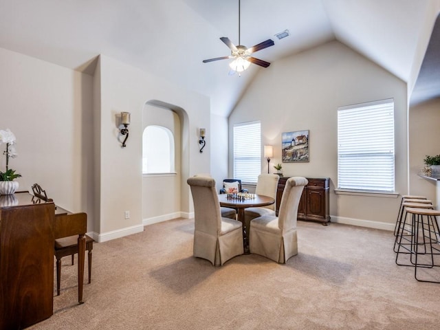 dining room with light carpet, a wealth of natural light, ceiling fan, and vaulted ceiling