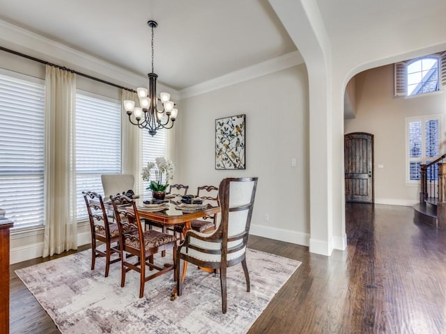 dining area with dark hardwood / wood-style flooring, crown molding, and a chandelier