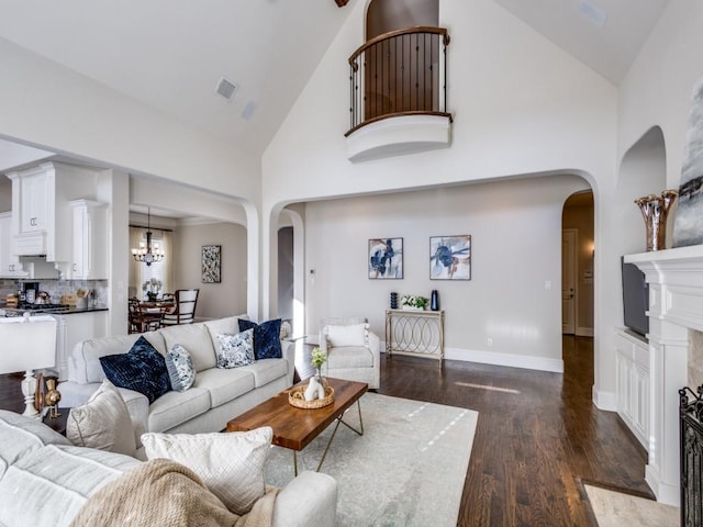 living room with dark hardwood / wood-style flooring, high vaulted ceiling, and a chandelier