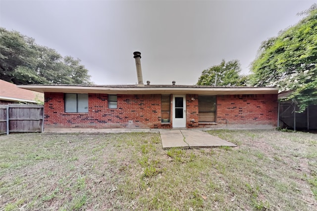 rear view of property with a lawn and a patio