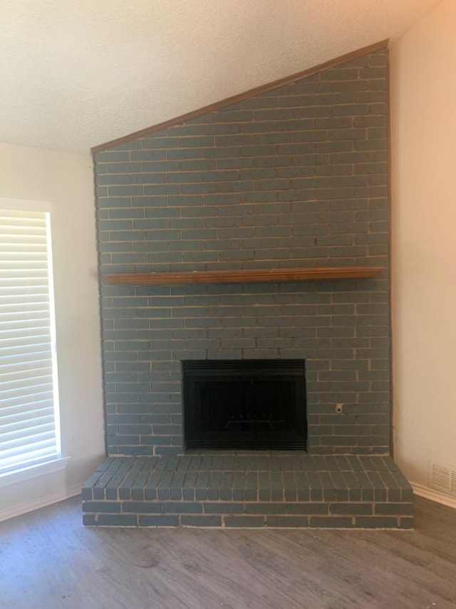 5014 Brookhollow Dr, Sachse, TX 75048 - detailed view of a brick fireplace, wood finished floors, baseboards, and a textured ceiling