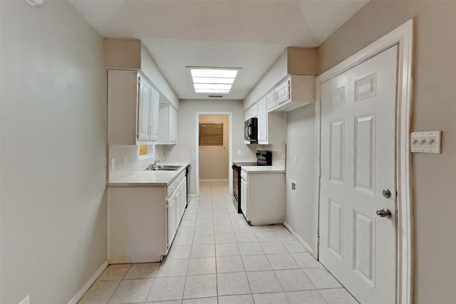 kitchen with white cabinetry, sink, black appliances, and light tile patterned flooring