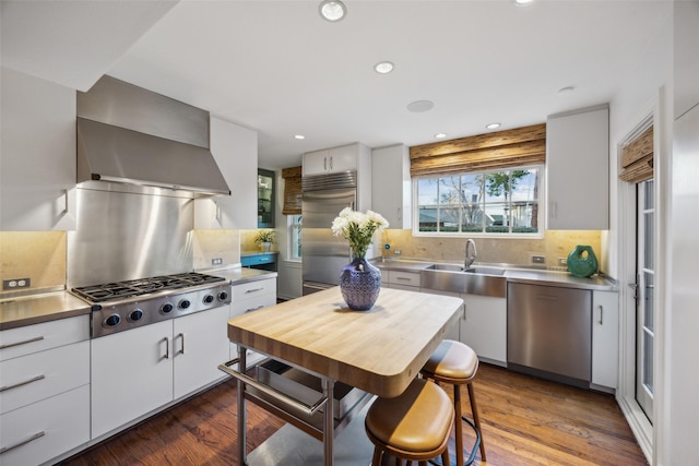 kitchen with tasteful backsplash, dark hardwood / wood-style floors, white cabinets, and appliances with stainless steel finishes