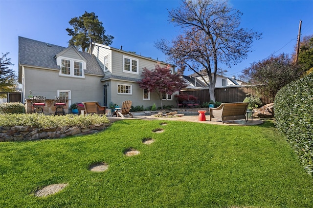 back of house with a lawn and a patio