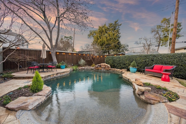 pool at dusk featuring a patio area