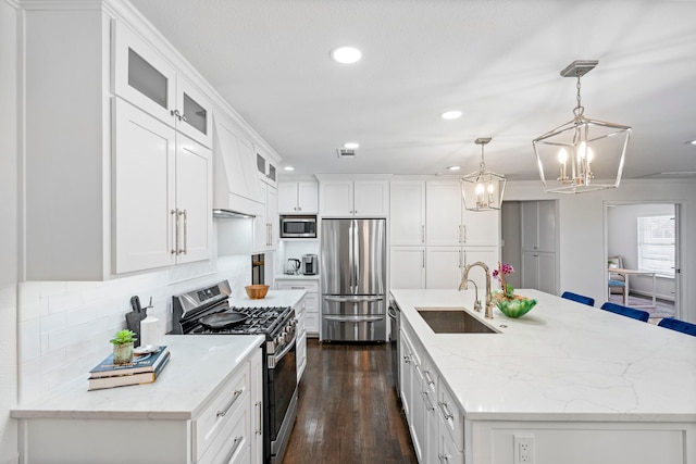 kitchen with white cabinetry, an island with sink, stainless steel appliances, and sink