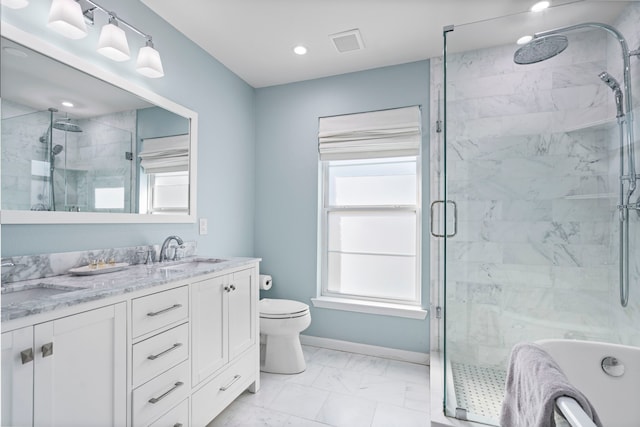 bathroom featuring vanity, toilet, and a shower with shower door