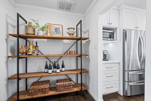 interior space with ornamental molding, stainless steel appliances, dark hardwood / wood-style floors, and white cabinets