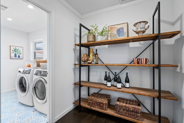 clothes washing area with crown molding and separate washer and dryer