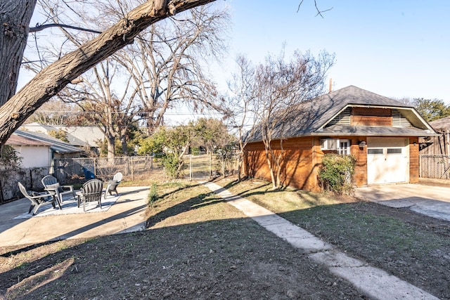 view of yard featuring a garage, an outdoor structure, and a patio area