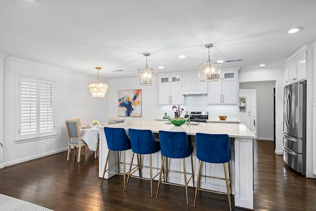 kitchen featuring pendant lighting, a large island, stainless steel appliances, white cabinets, and decorative backsplash