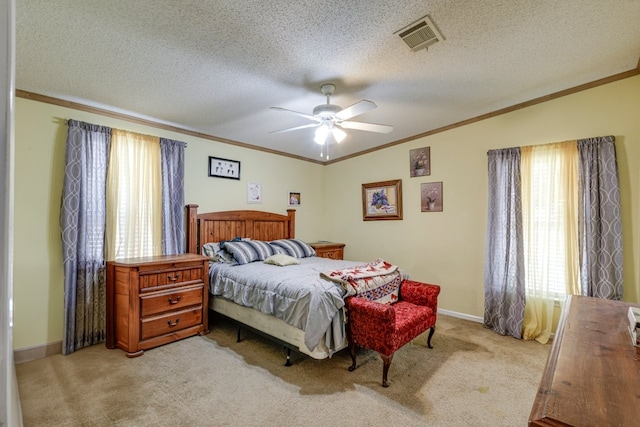 bedroom with ceiling fan, light colored carpet, multiple windows, and a textured ceiling