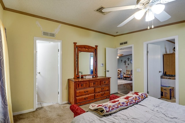 bedroom featuring a textured ceiling, ornamental molding, light colored carpet, and ceiling fan