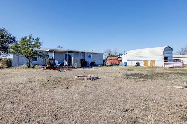 back of property with an outbuilding and an outdoor fire pit