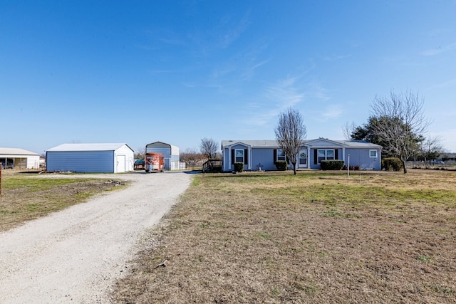 ranch-style home with a garage, an outdoor structure, and a front yard