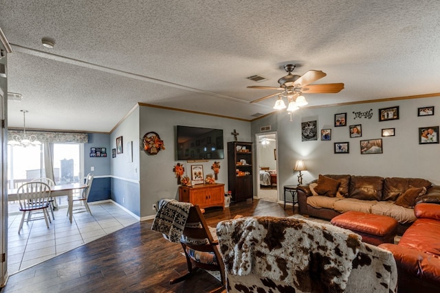 living room with ceiling fan with notable chandelier, wood-type flooring, ornamental molding, and a textured ceiling