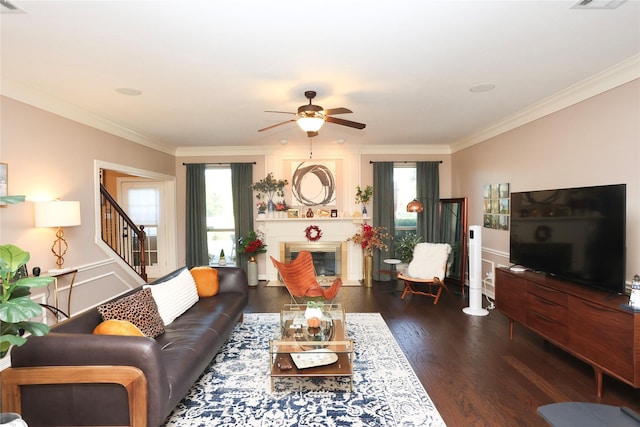 living room featuring dark hardwood / wood-style flooring, crown molding, and ceiling fan