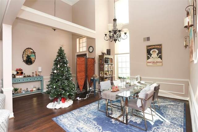 dining room featuring a high ceiling, hardwood / wood-style floors, and an inviting chandelier