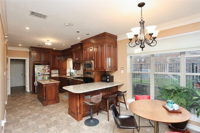 kitchen featuring crown molding, kitchen peninsula, pendant lighting, stainless steel appliances, and light stone countertops