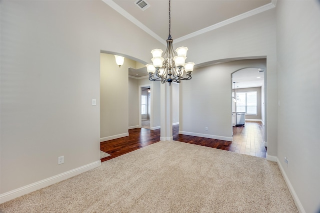 unfurnished room featuring crown molding, a notable chandelier, vaulted ceiling, and dark colored carpet