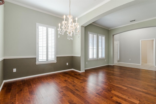 unfurnished room with crown molding, dark hardwood / wood-style floors, and a notable chandelier