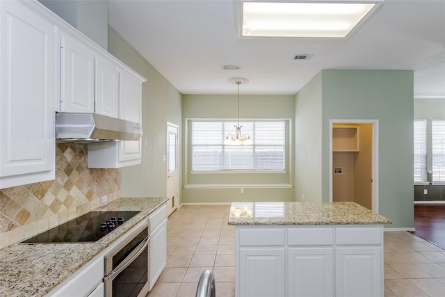 kitchen with tasteful backsplash, white cabinetry, oven, a center island, and black electric cooktop