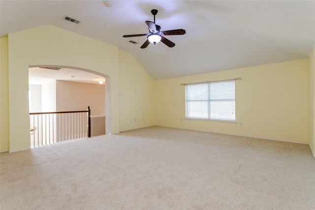 carpeted empty room featuring lofted ceiling, ceiling fan, and a healthy amount of sunlight