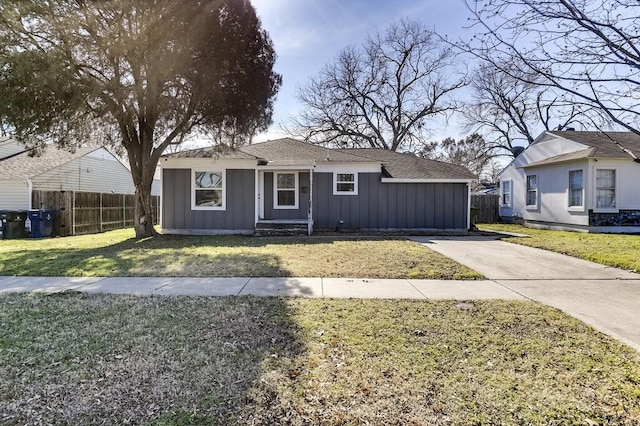 bungalow-style house featuring board and batten siding, driveway, a front yard, and fence